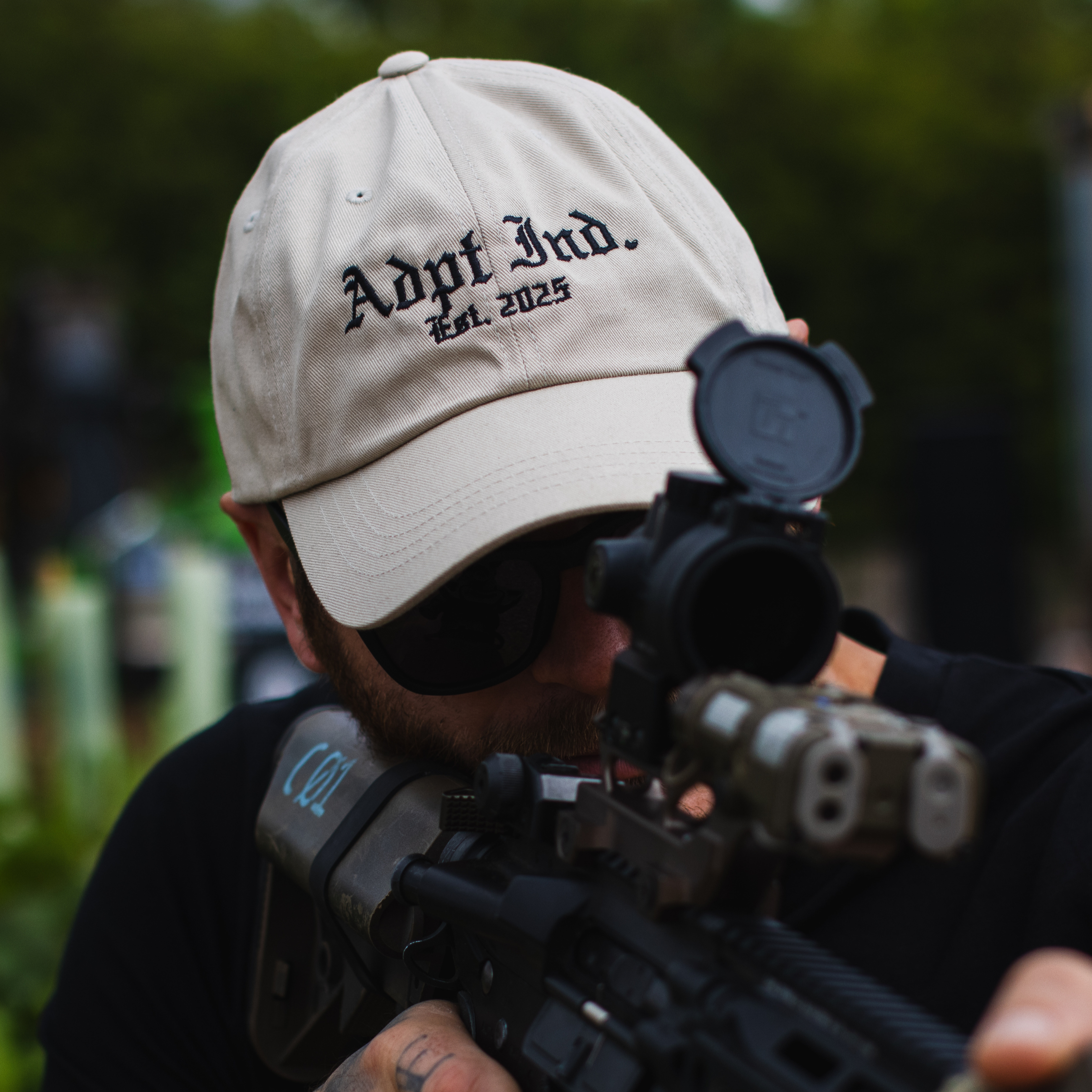 Soldier shooting while wearing a dad hat with embroidered logo on the front.