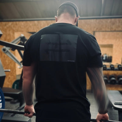 Person holding a barbell in a gym setting